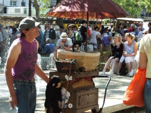 One of those unusual characters at the market. Check out the doggie in the basket.